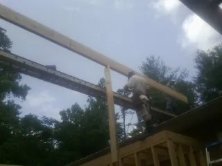 Carpenter setting a ridge beam over a new addition frame — Ice Dam Removal by Roofing Brothers in Valley Head
