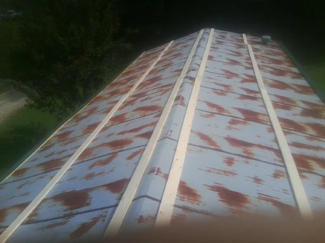Rusted metal roof panels with new wood purlins before replacement — Storm Damage Roof Repair in Valley Head by Roofing Brothers