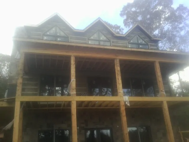 Dormers and porch framing on a large log home under construction — Roof Coating work by our crew in Valley Head