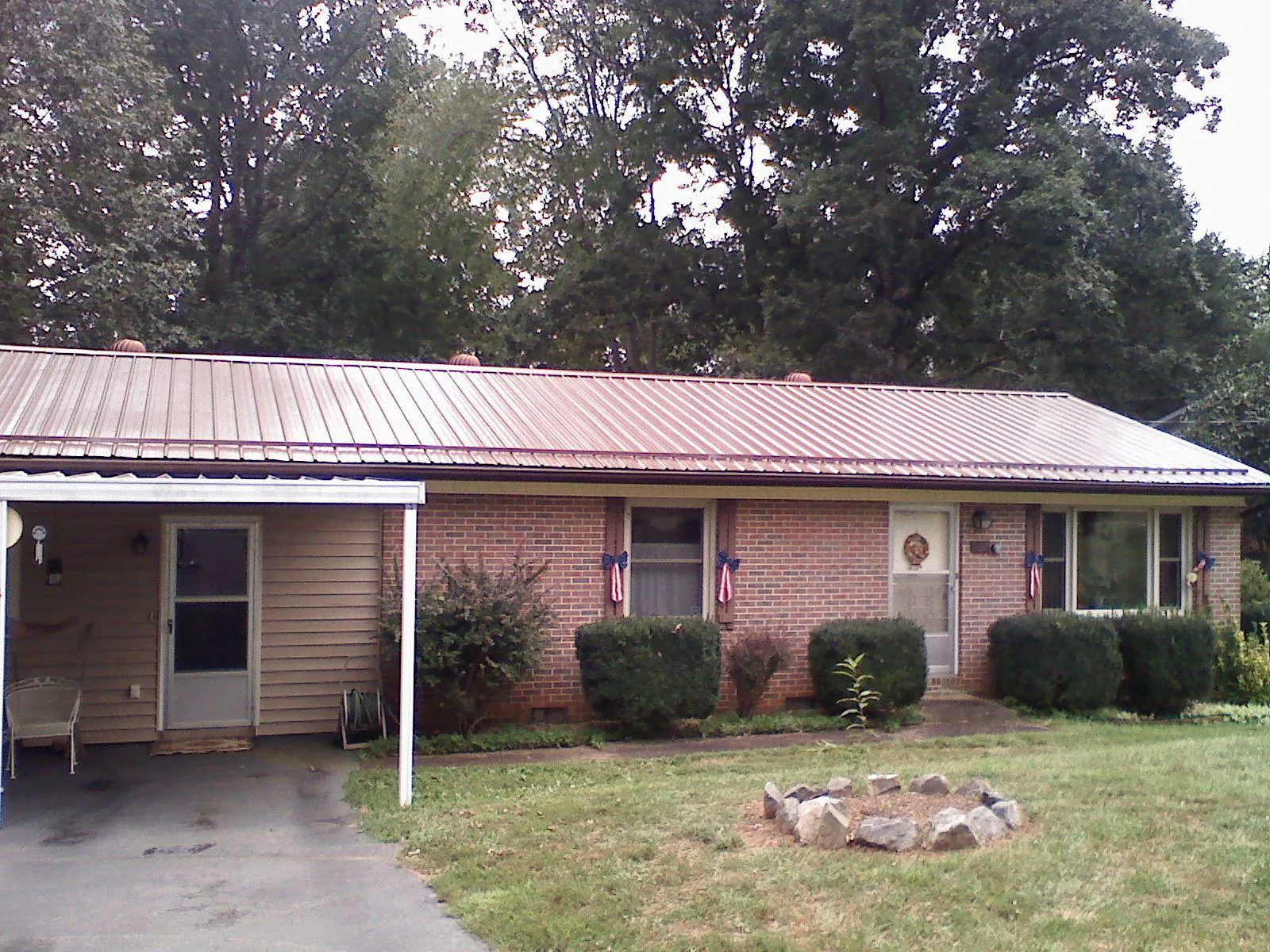 Bronze metal roof and carport on a brick ranch home — Roof Repair work by our crew in Valley Head